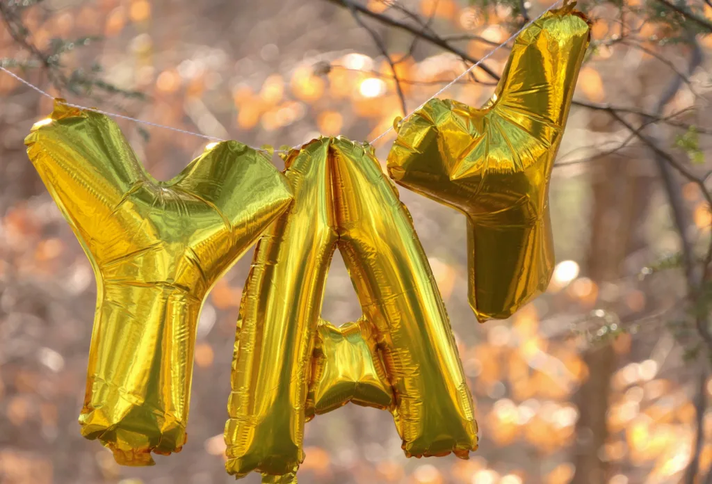 Big golden balloons in the shape of letters spelling YAY