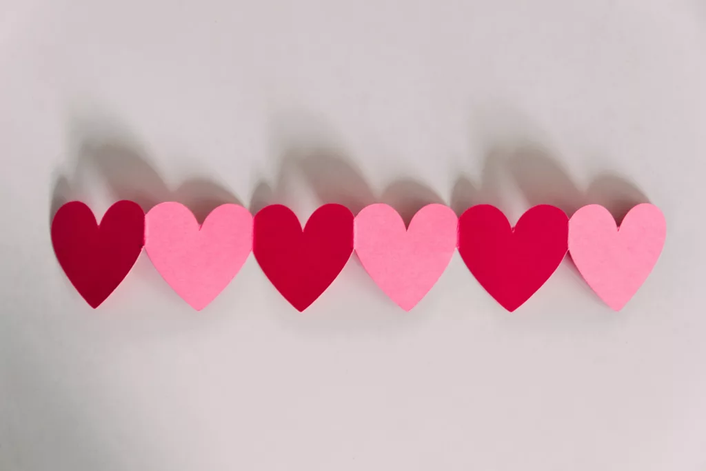 Some red and pink paper hearts in a row