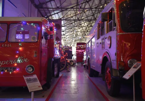 Vintage buses in a transport museum with Christmas lights