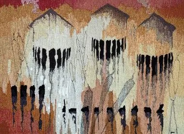 Woven tapestry in rust, cream and black showing three house-like shapes above dripping vertical lines