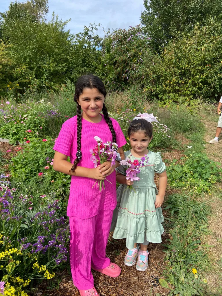 Two young people standing in front of a field with flowers