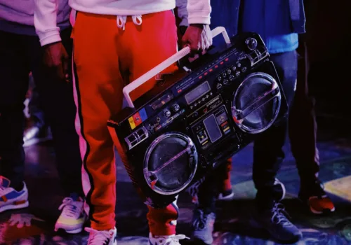 man in red jacket holding black dj controller